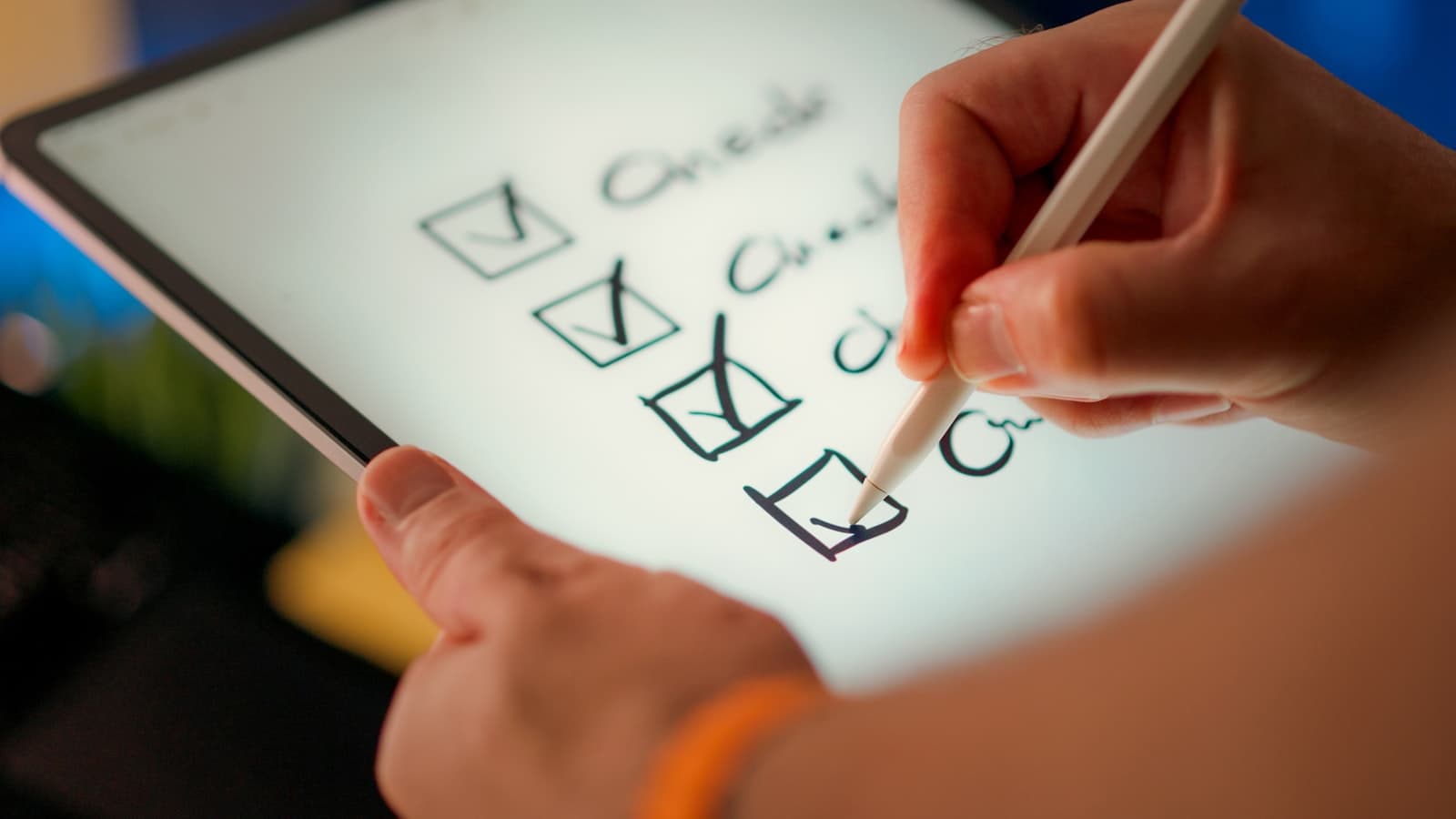 Hand ticking checkboxes on a tablet checklist