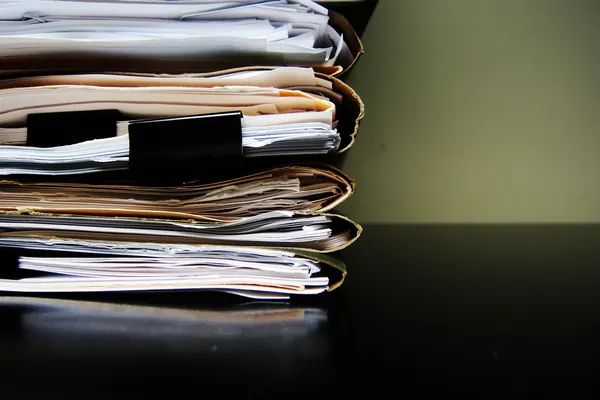 Stack of paper files held by binder clips