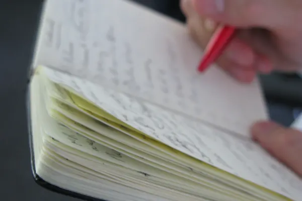Hand taking notes in a notebook
